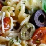 Bowl of colorful Italian pasta salad with fresh vegetables and dressing